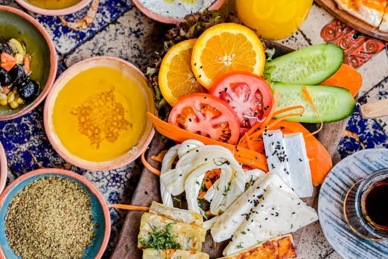 Colourful table of fresh vegetables, soup, grains and citrus