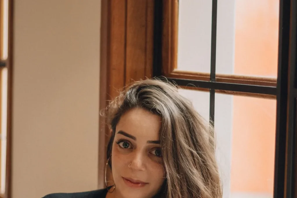 Calm woman with long hair resting by a sunlit window