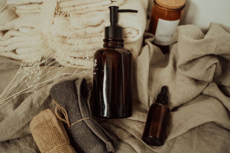 Amber glass pump and dropper bottles resting on natural linen cloth